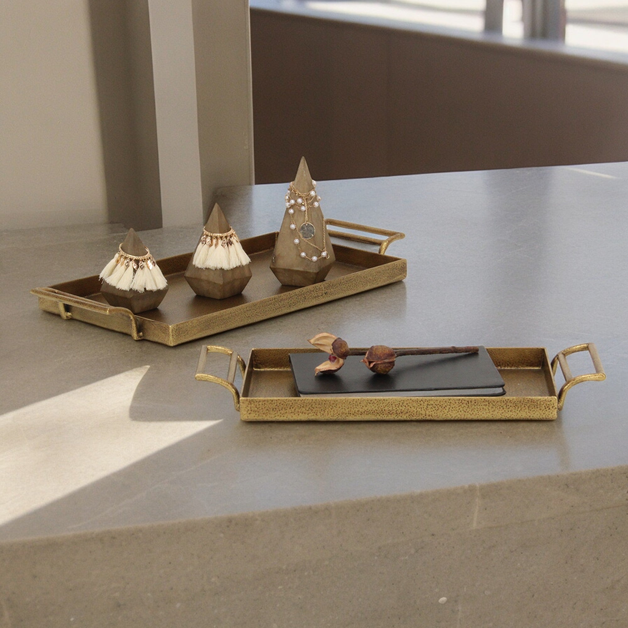 Picture of a set of 2 cast iron tray set with decorative objects on top.